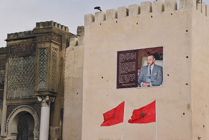 Moroccan flags in front King Mohammed VI picture, Meknes
